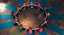 Yogis in orderly circle holding hands